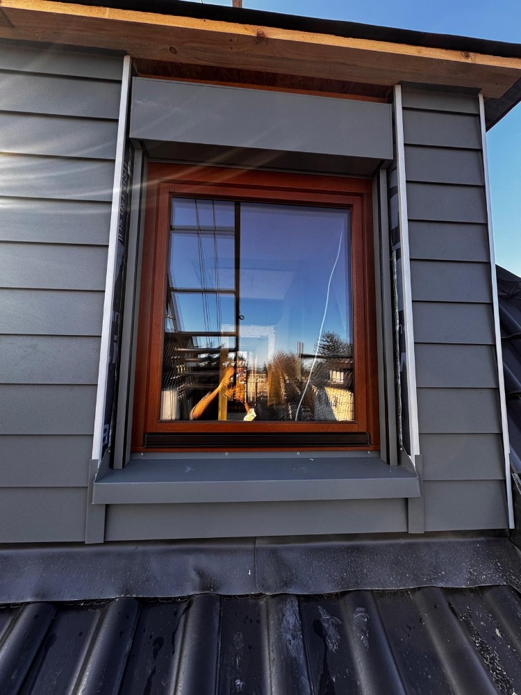 Traditionelles Fachwerkhaus mit grünen Fensterläden und verzierter Beschilderung.